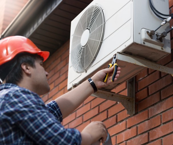 Outdoor AC unit with man repairing it 