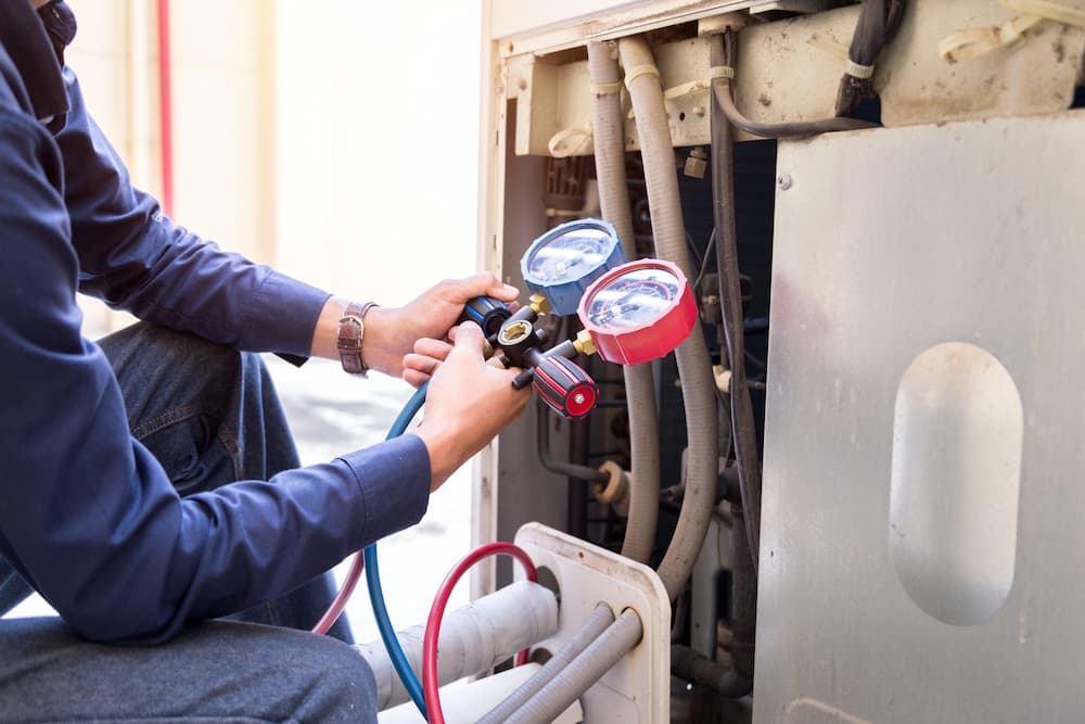 Technician is checking air conditioner measuring equipment for filling air conditioners.