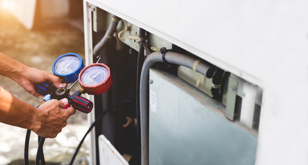 Air repair mechanic using measuring equipment for filling industrial factory