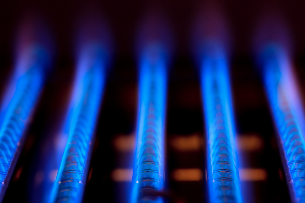 Blue flames of natural gas burning inside of a boiler